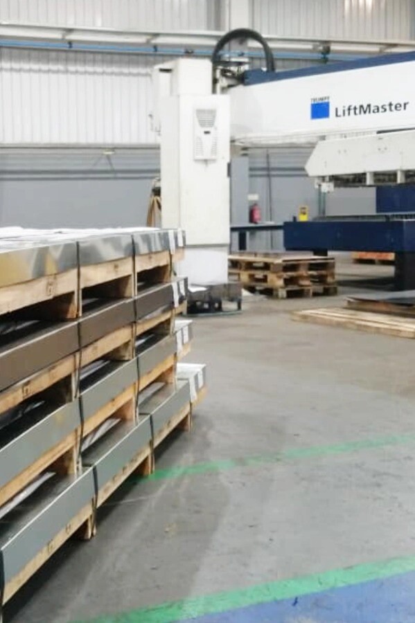 Trumpf TruLaser 3030 fiber laser cutting machine at V Laser On in Porto, Portugal, with pallet of metal sheets and Lift Master material handling system, illustrating precision industrial metal fabrication