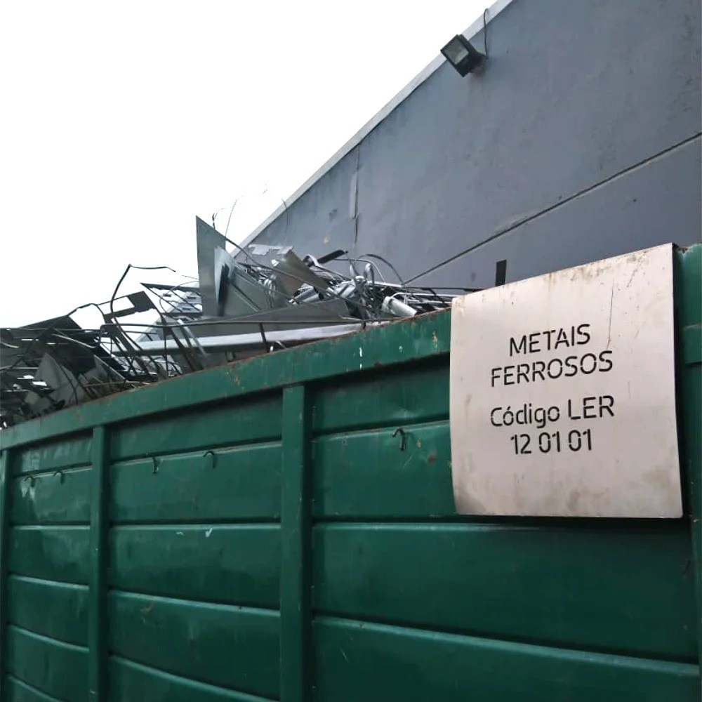 Industrial container with leftover laser-cut metal sheets, sorted by material type for recycling at V Laser On in Porto, Portugal, illustrating circular production and metal waste management