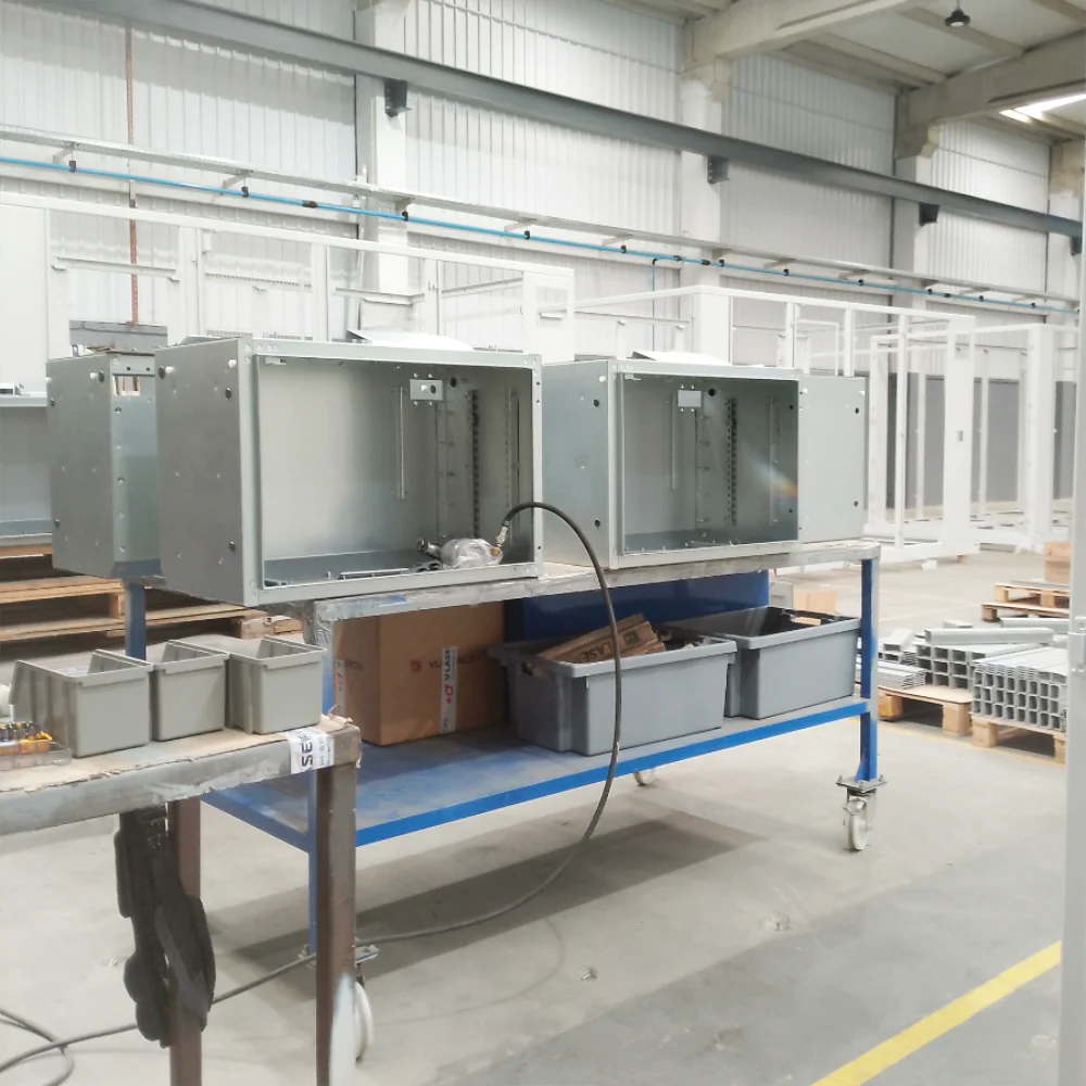 Galvanized steel electrical cabinets being assembled on a workbench at V Laser On factory in Porto Portugal, showcasing precision industrial assembly of metal components