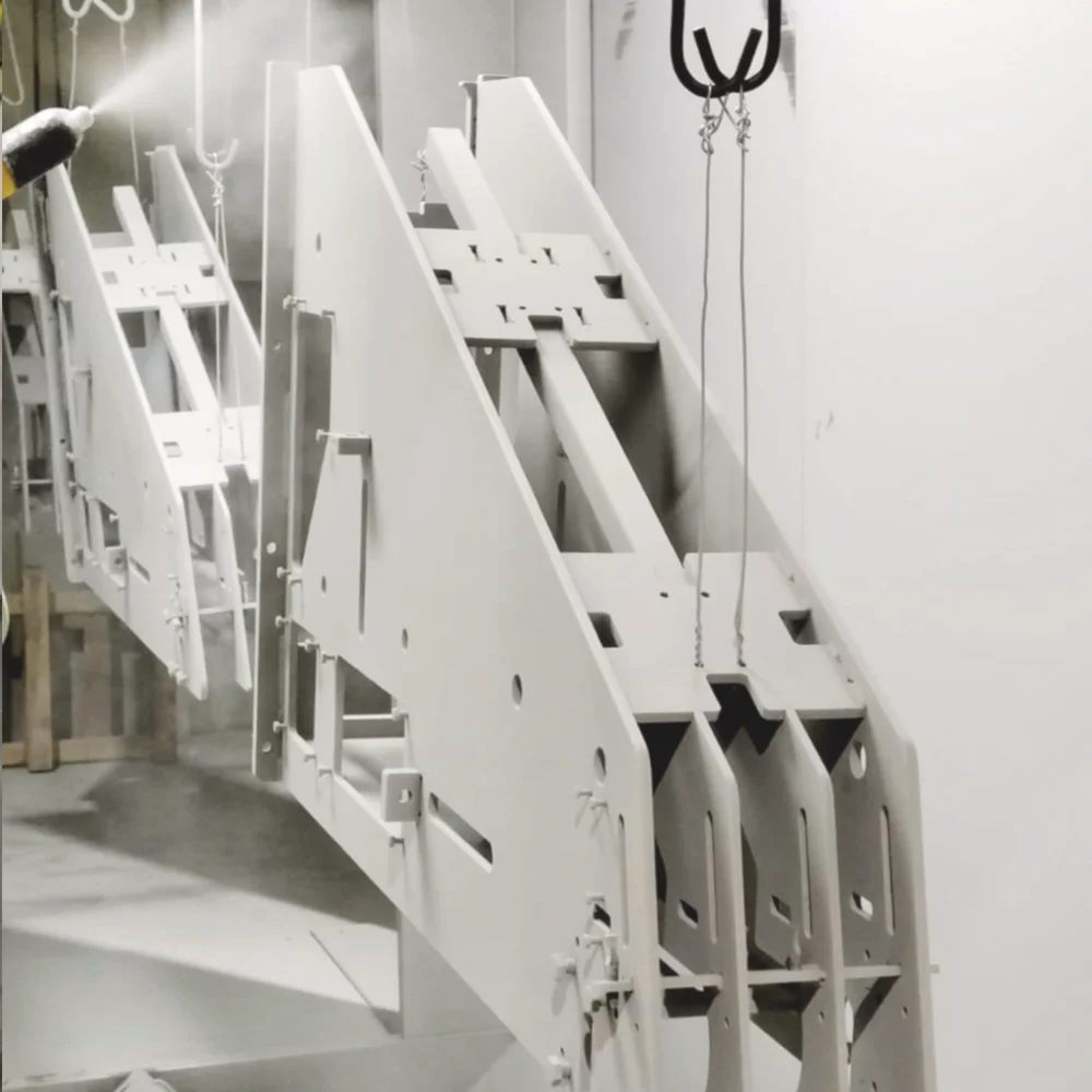 Large, complex welded metal structure being painted white at V Laser On workshop in Porto Portugal, showcasing high-quality industrial powder coating for intricate assemblies
