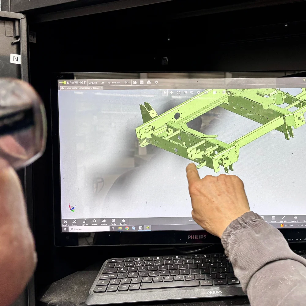 Welder consulting a CAD technical drawing on a screen before welding a component at V Laser On in Porto Portugal, demonstrating precision planning for industrial aluminium and steel assemblies