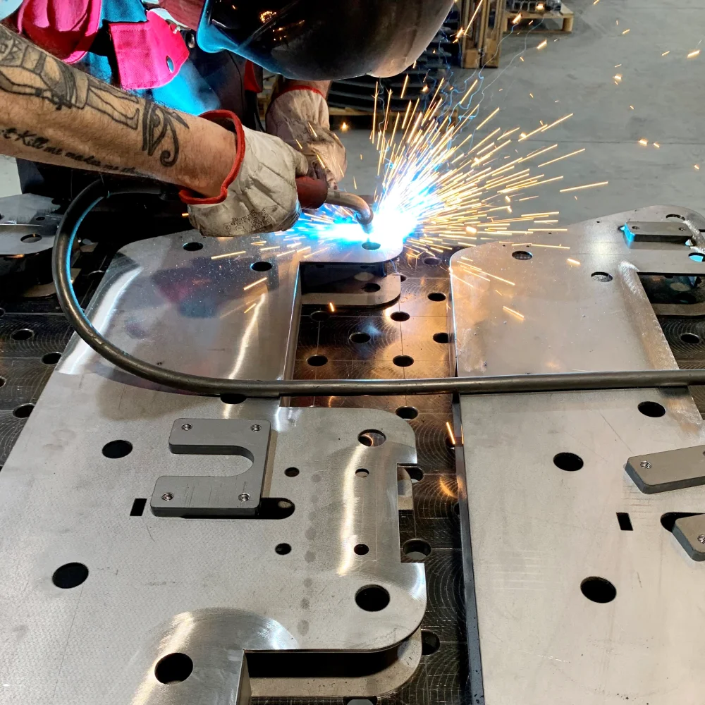Welder performing manual welding on a carbon steel and iron structure at V Laser On workshop in Porto Portugal, showcasing precision industrial welding for large assemblies